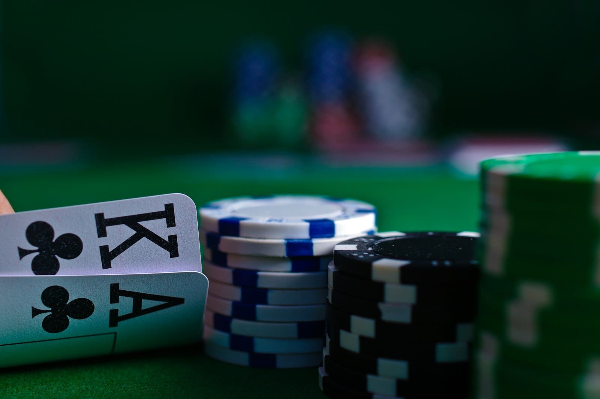 Playing cards and stacked chips on a green gaming table
