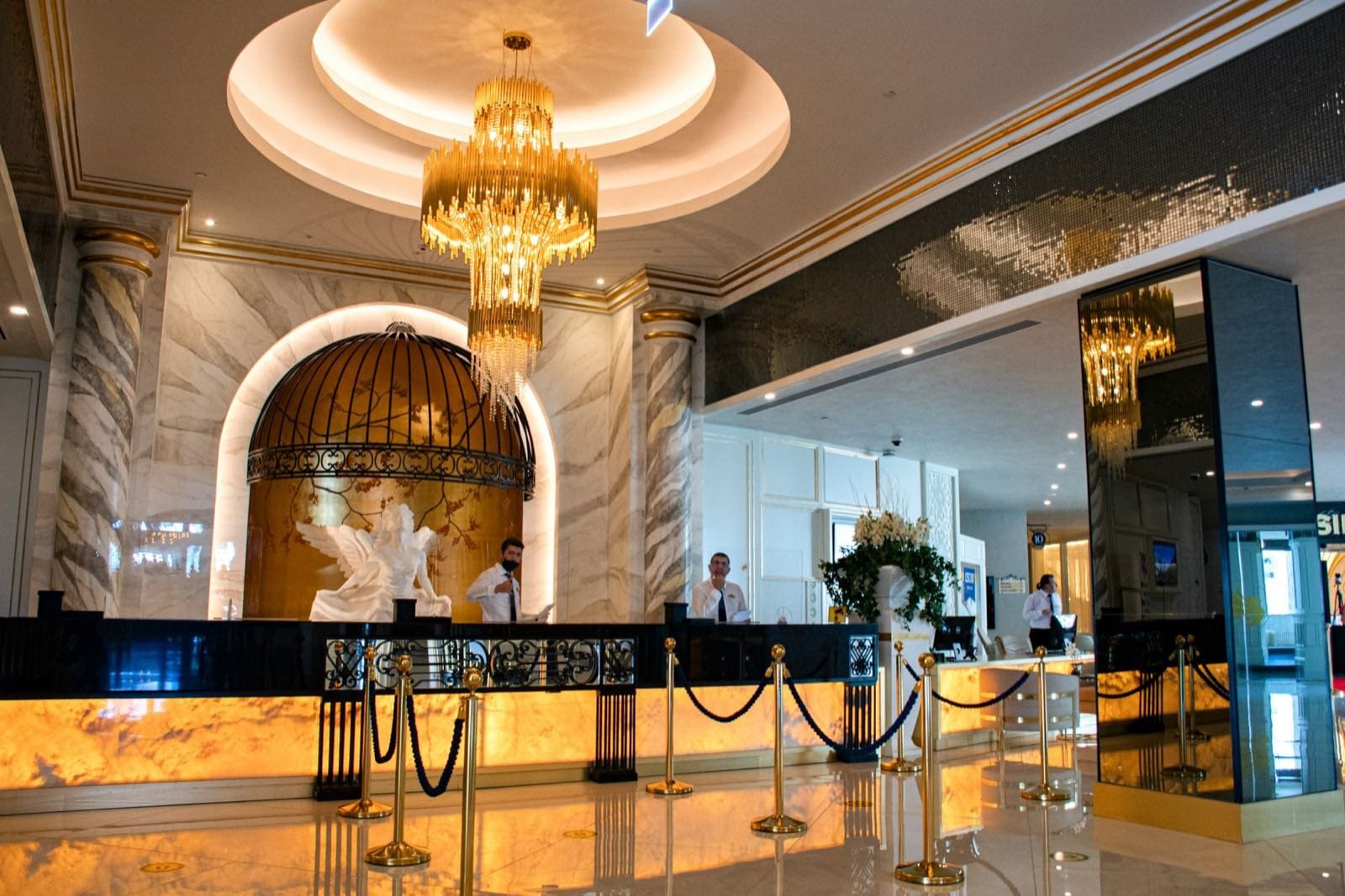 Resort lobby with a gold chandelier and marble columns