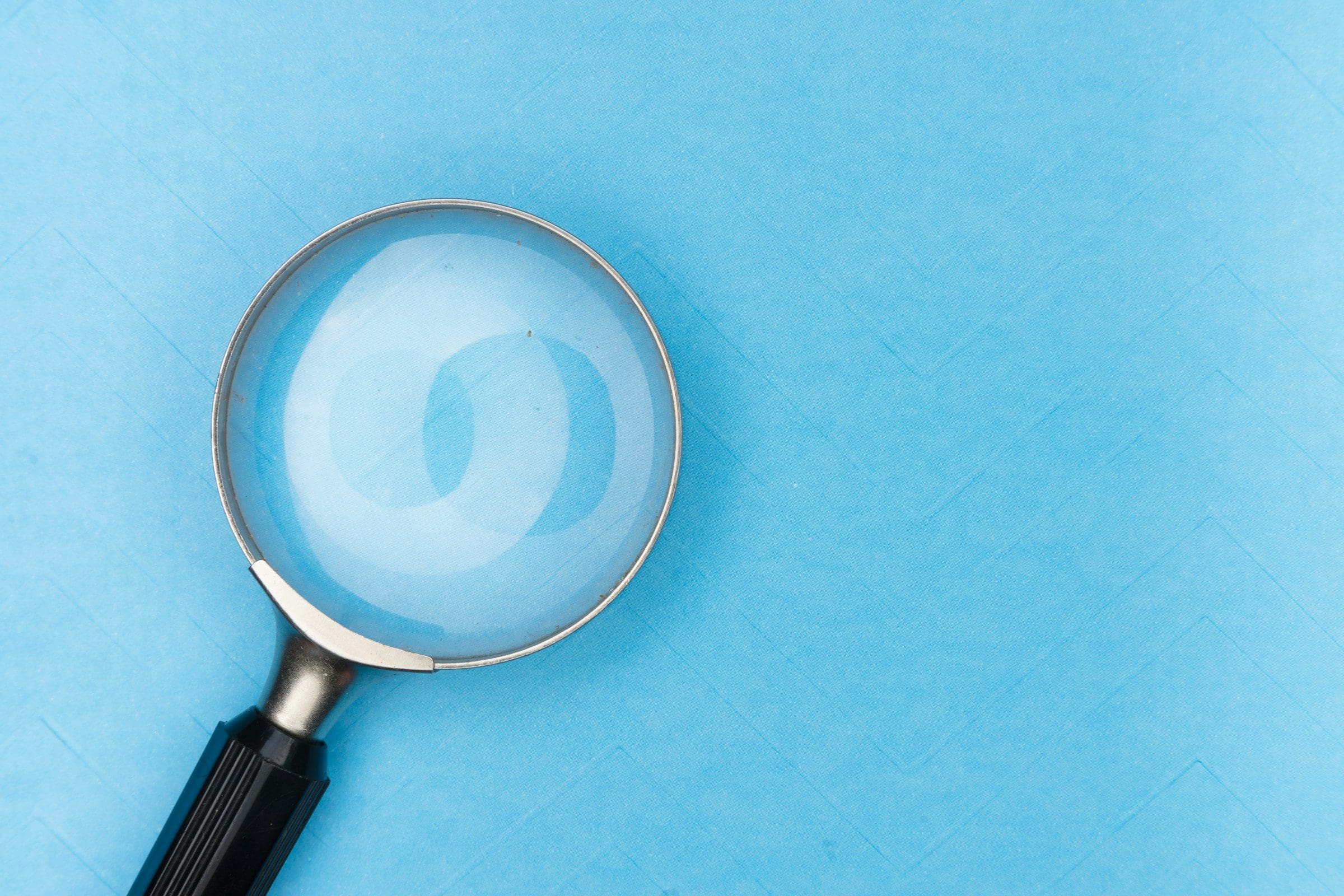 A magnifying glass resting on a white table